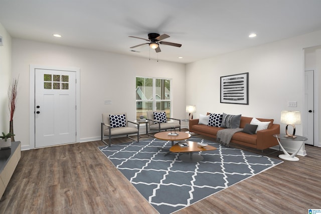 living room featuring ceiling fan and dark hardwood / wood-style floors