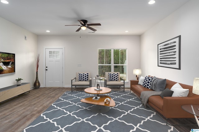 living room with dark hardwood / wood-style flooring and ceiling fan