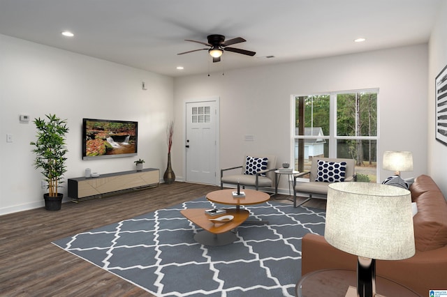 living room featuring ceiling fan and dark hardwood / wood-style floors