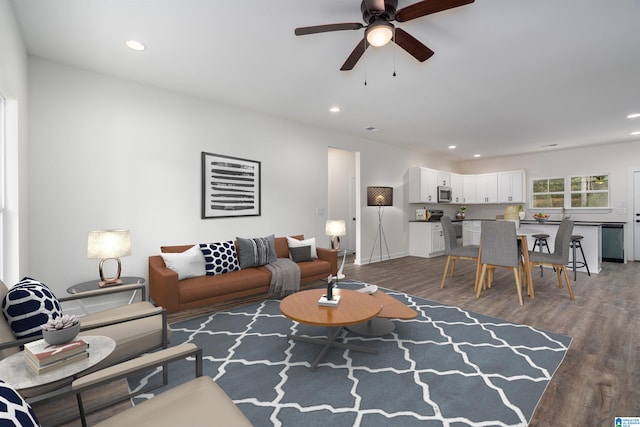 living room with ceiling fan and dark wood-type flooring