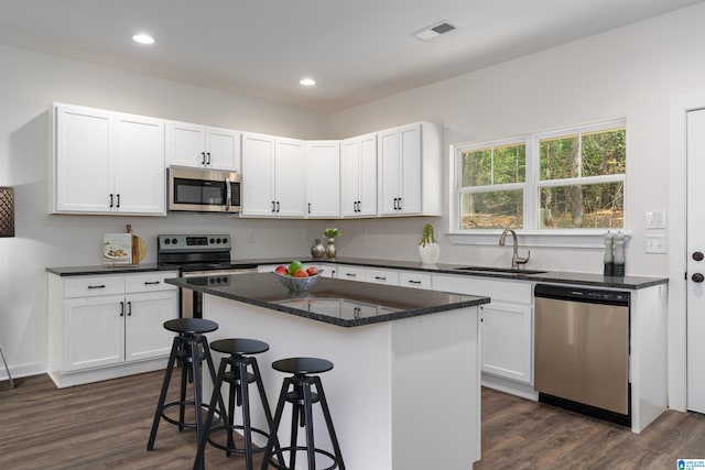 kitchen with white cabinets, dark hardwood / wood-style flooring, stainless steel appliances, and sink