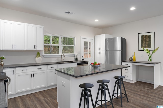 kitchen with white cabinets, sink, stainless steel appliances, and dark wood-type flooring