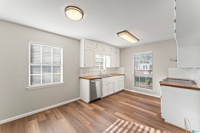 kitchen with dishwasher, sink, wood counters, wood-type flooring, and white cabinets