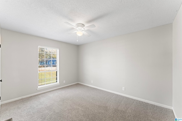 spare room featuring a textured ceiling, carpet floors, and ceiling fan