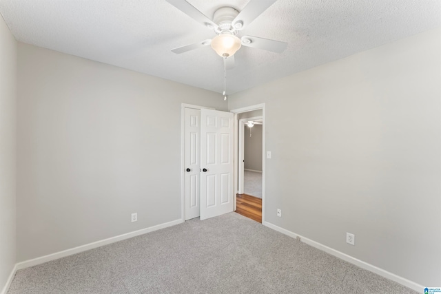 unfurnished room with ceiling fan, carpet floors, and a textured ceiling