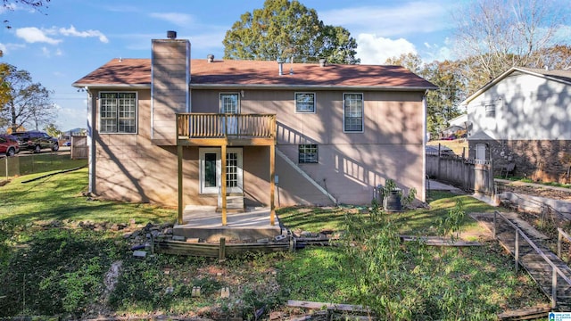 back of property with a wooden deck and a yard