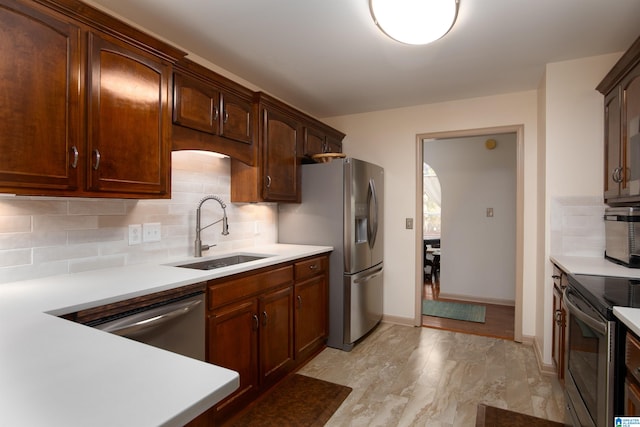 kitchen featuring decorative backsplash, appliances with stainless steel finishes, and sink