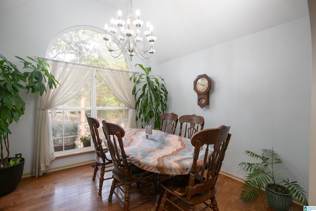 dining space featuring hardwood / wood-style flooring, vaulted ceiling, and a chandelier