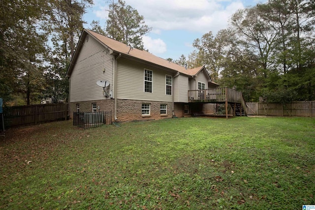 back of property featuring a yard and a wooden deck