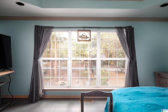 tiled bedroom featuring multiple windows and crown molding