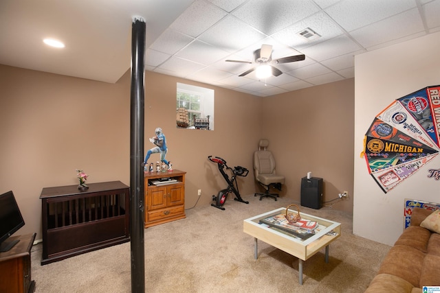 carpeted living room featuring a drop ceiling and ceiling fan