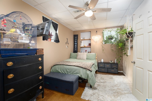 bedroom featuring ceiling fan, a drop ceiling, and carpet floors