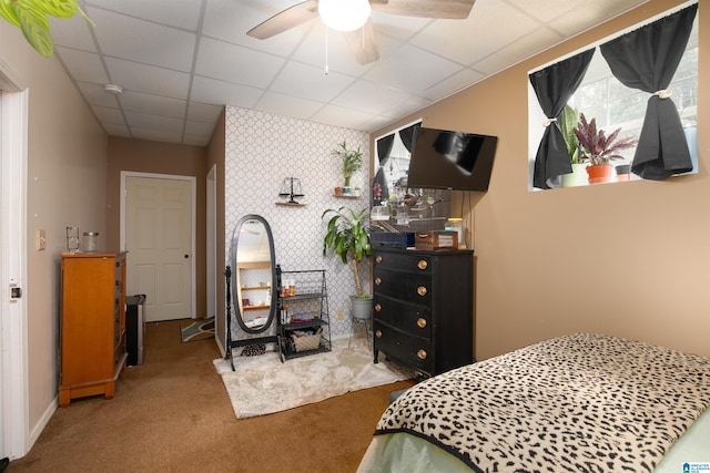 carpeted bedroom featuring a drop ceiling and ceiling fan