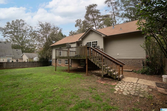 rear view of house featuring a yard and a deck