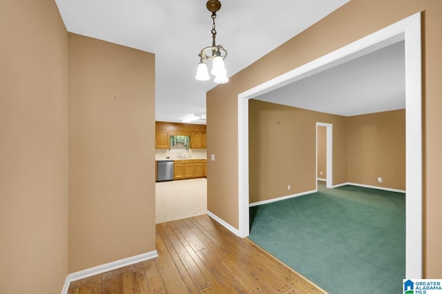 spare room featuring wood-type flooring and an inviting chandelier