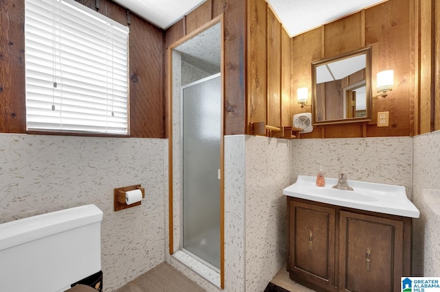 bathroom featuring wood walls, a shower with shower door, and a textured ceiling