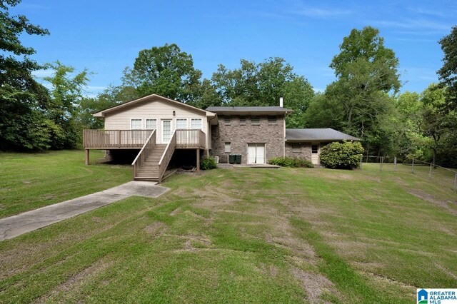 view of front of property featuring a front lawn, a deck, and a garage