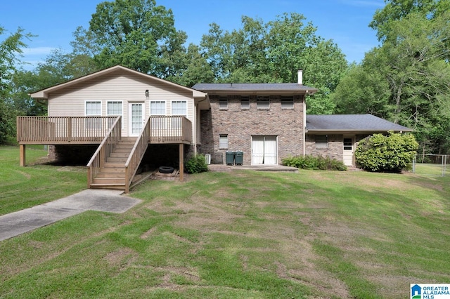 back of property with a lawn and a wooden deck