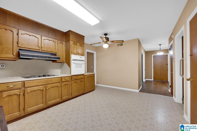 kitchen featuring stovetop, white oven, decorative light fixtures, and ceiling fan