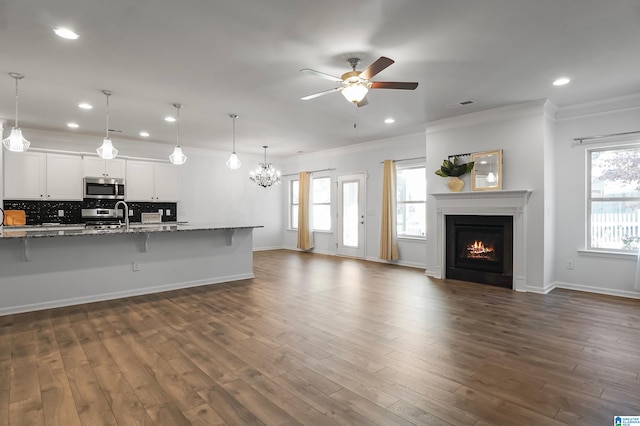 kitchen with a breakfast bar area, a healthy amount of sunlight, white cabinets, and stainless steel appliances