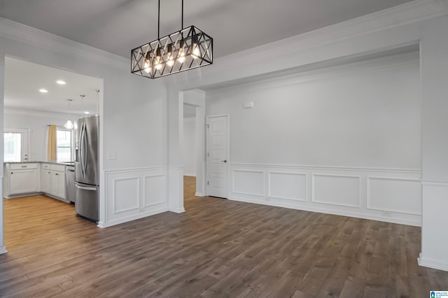 unfurnished dining area with dark hardwood / wood-style flooring, crown molding, and an inviting chandelier