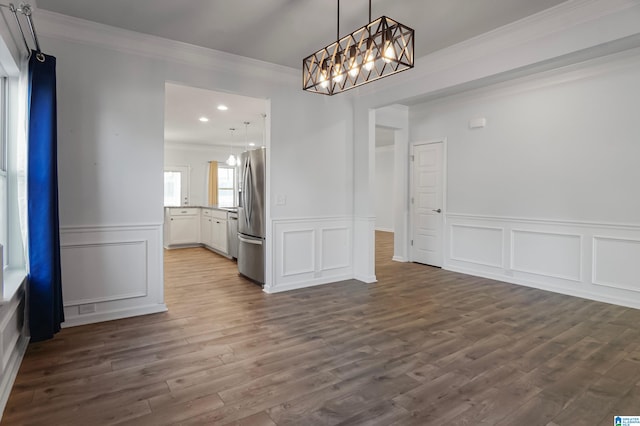 unfurnished dining area with a notable chandelier, dark hardwood / wood-style floors, and ornamental molding