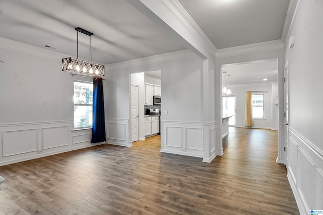 unfurnished dining area with hardwood / wood-style flooring and ornamental molding