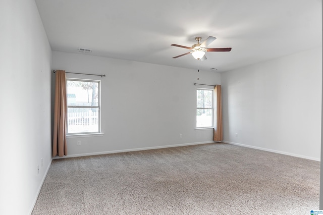 spare room featuring carpet, plenty of natural light, and ceiling fan