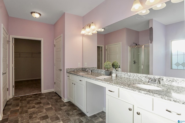 bathroom with a shower with door and vanity