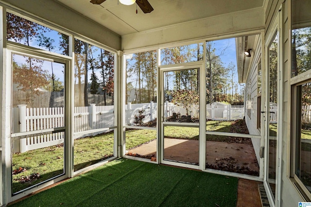 unfurnished sunroom with ceiling fan