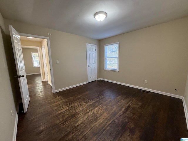 empty room with dark hardwood / wood-style flooring