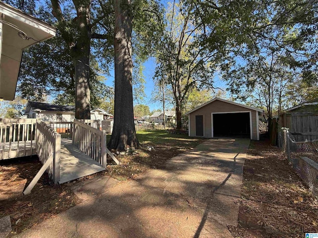 view of yard featuring a garage, an outdoor structure, and a deck