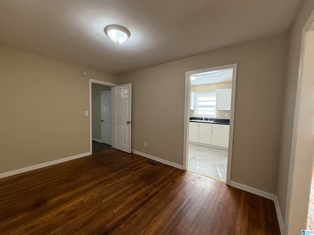 empty room featuring dark hardwood / wood-style flooring and sink