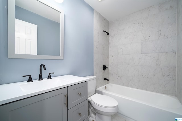 full bathroom with tiled shower / bath, vanity, and toilet