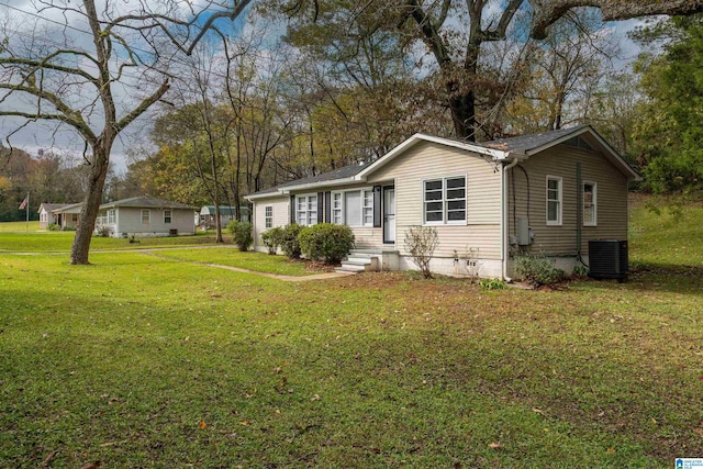 view of front of house featuring central AC unit and a front lawn