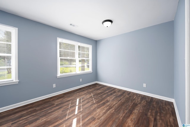 unfurnished room with dark wood-type flooring