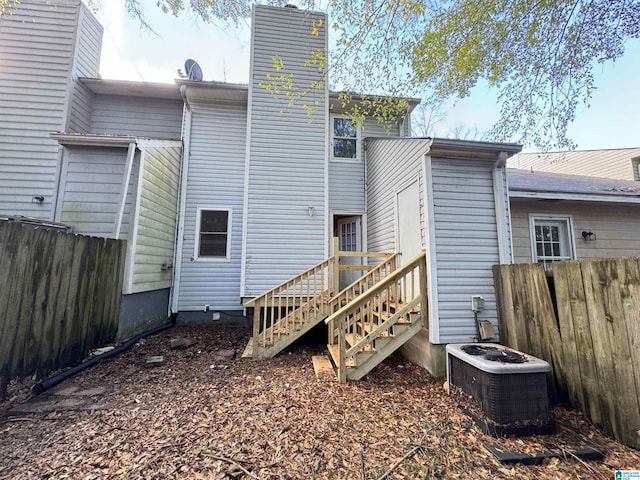 5807 Woodgate Cir, Anniston, AL 36207 - back of property with central AC, a chimney, and stairway