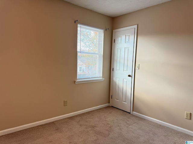 carpeted spare room with a textured ceiling