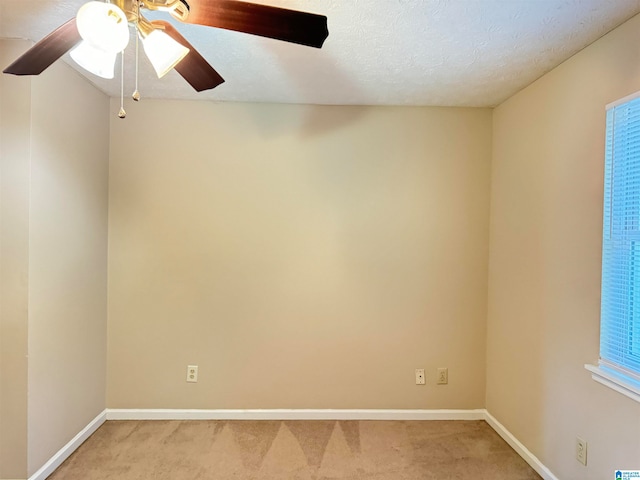 carpeted empty room with a textured ceiling, ceiling fan, and a healthy amount of sunlight