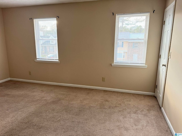 spare room featuring light colored carpet