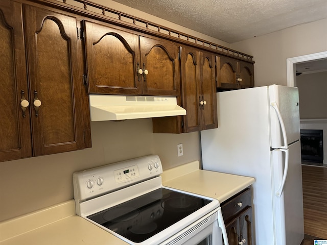 5807 Woodgate Cir, Anniston, AL 36207 - kitchen with white appliances, under cabinet range hood, dark brown cabinets, light countertops, and a textured ceiling