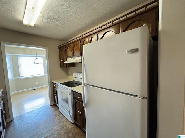 5807 Woodgate Cir, Anniston, AL 36207 - kitchen featuring white appliances, under cabinet range hood, tile patterned floors, dark brown cabinetry, and light countertops