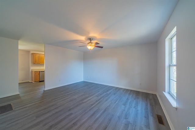 unfurnished living room with a wealth of natural light, ceiling fan, and dark wood-type flooring