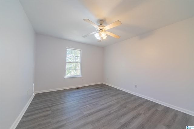 empty room with ceiling fan and dark wood-type flooring