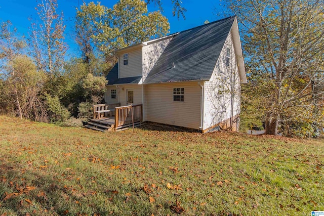 rear view of house featuring a deck and a yard