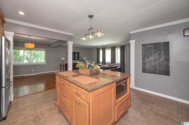 kitchen with plenty of natural light, crown molding, appliances with stainless steel finishes, and decorative columns