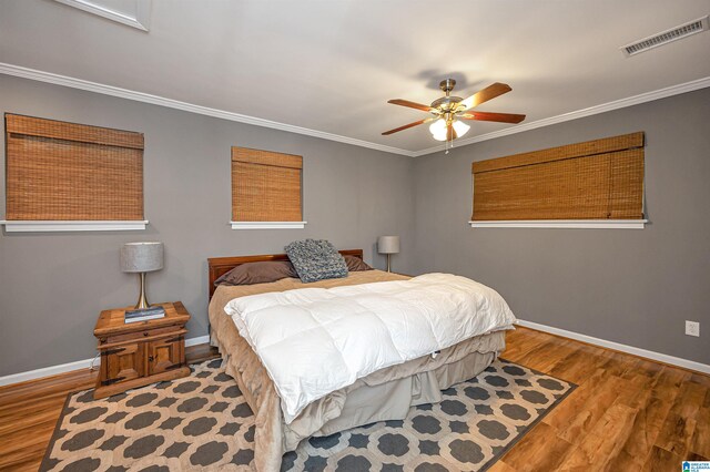 bedroom featuring ceiling fan, light wood-type flooring, and crown molding