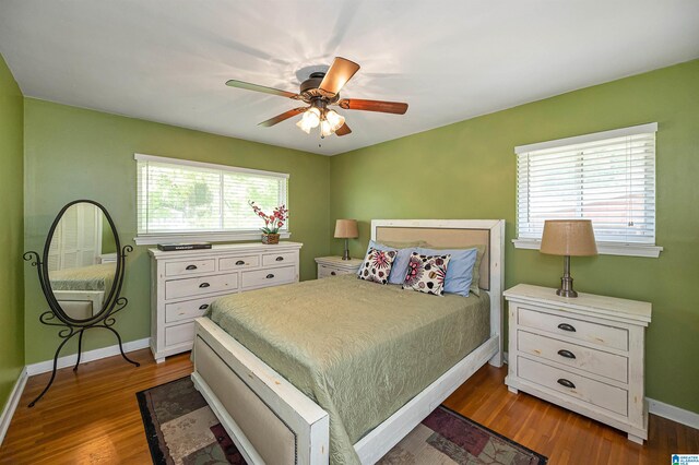 bedroom with multiple windows, ceiling fan, and dark hardwood / wood-style flooring