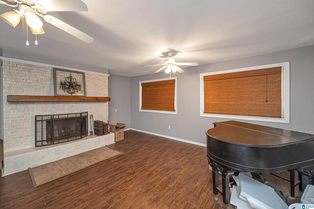 living room with a fireplace, ceiling fan, and dark hardwood / wood-style flooring