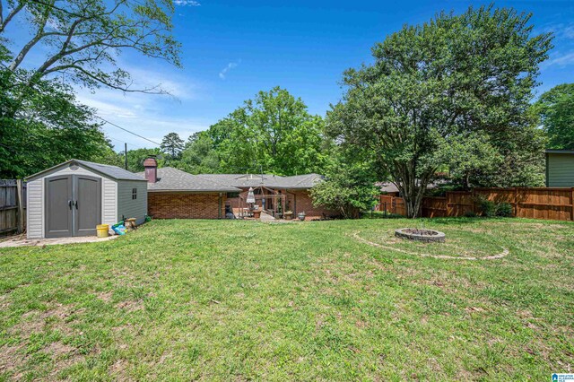 view of yard featuring an outdoor fire pit and a storage shed